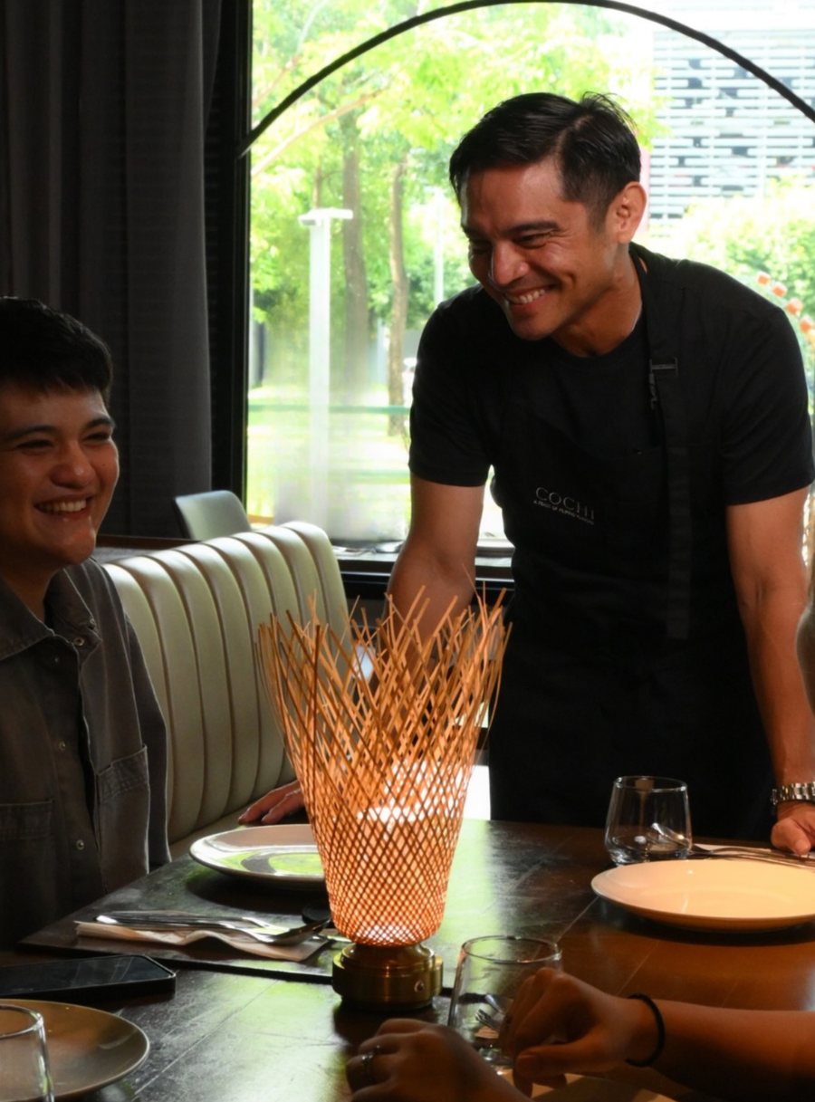 A restaurant host speaking with seated guests