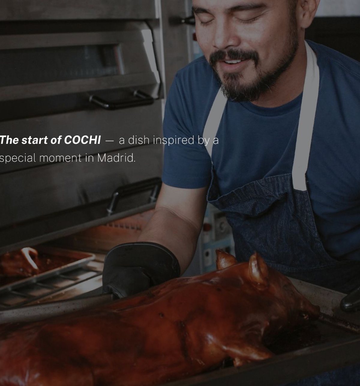 A cook standing over a roasted pig in a kitchen