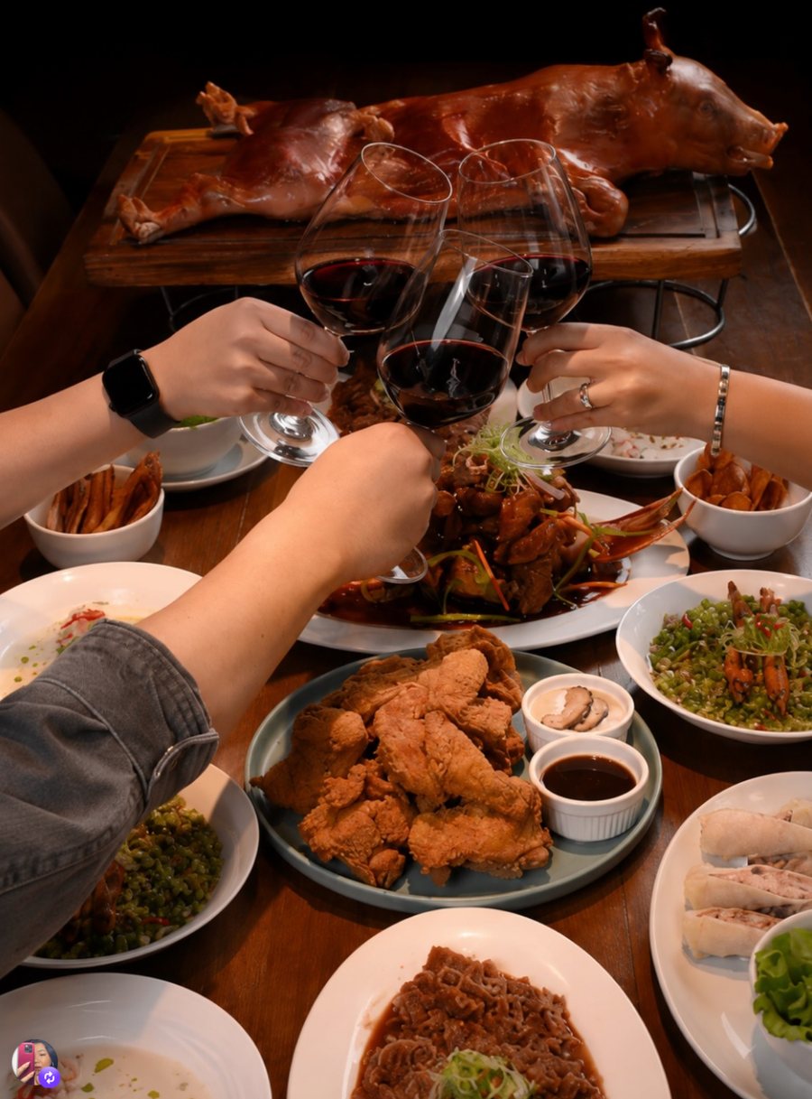 Guests raising wine glasses over a shared feast
